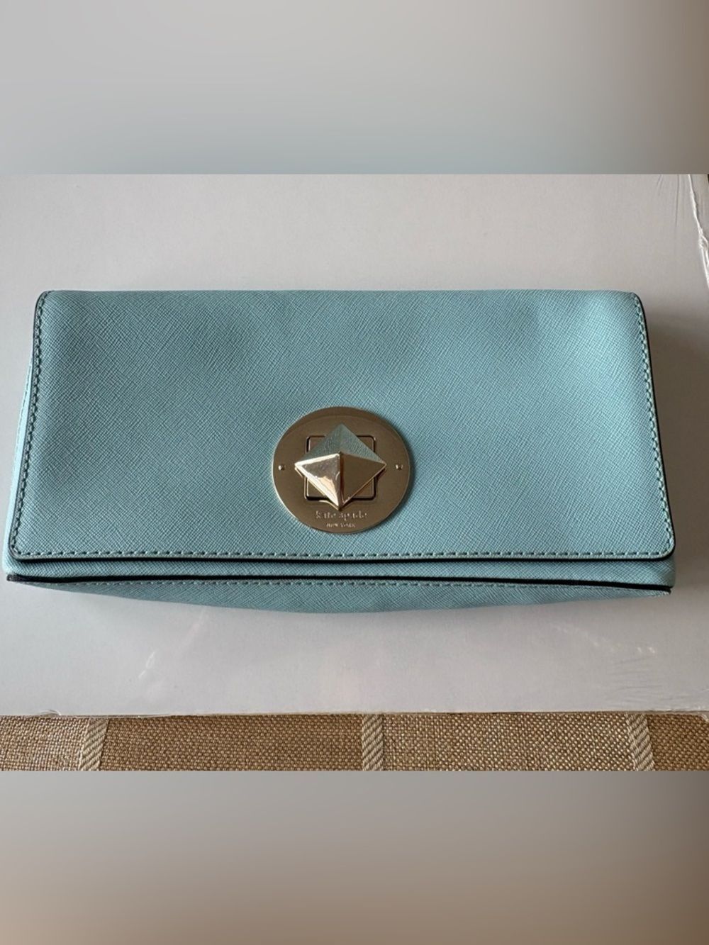 kate spade light turquoise leather clutch with gold-tone emblem